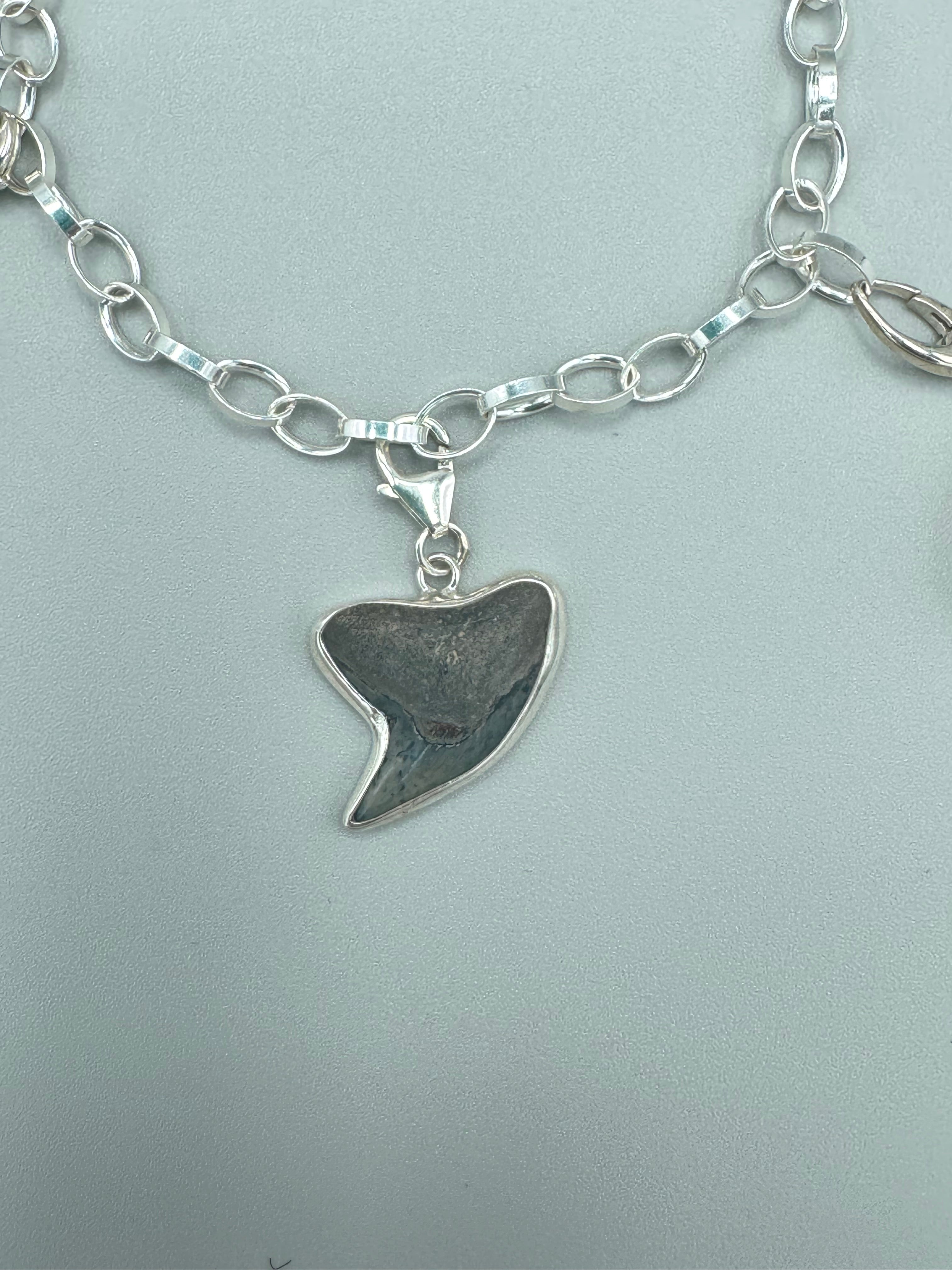 Historic charm bracelet featuring Sicilian red-glow black sea glass, fossilized shark tooth, and amber sea glass from England, set in sterling silver.