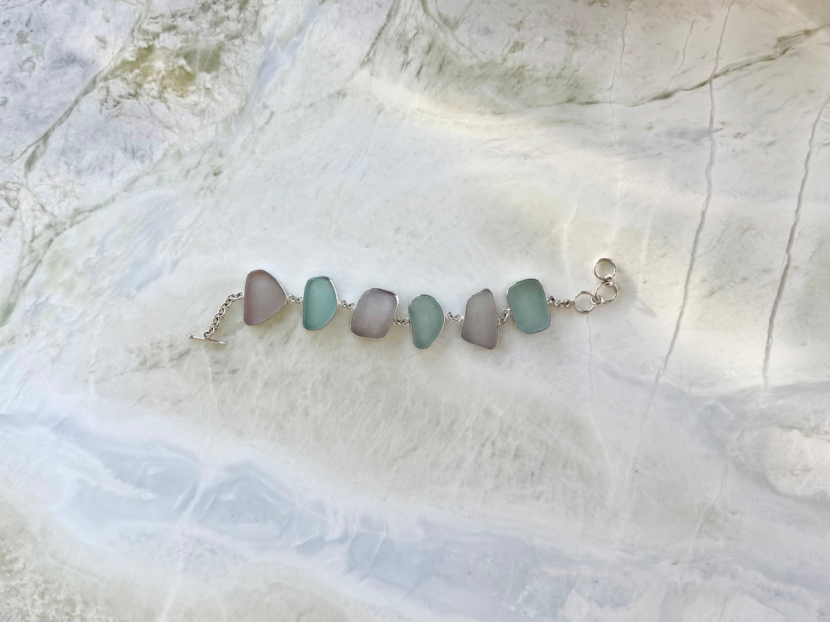 Sterling silver bracelet featuring pale blue and lavender sea glass from Glass Beach, Fort Bragg, California.