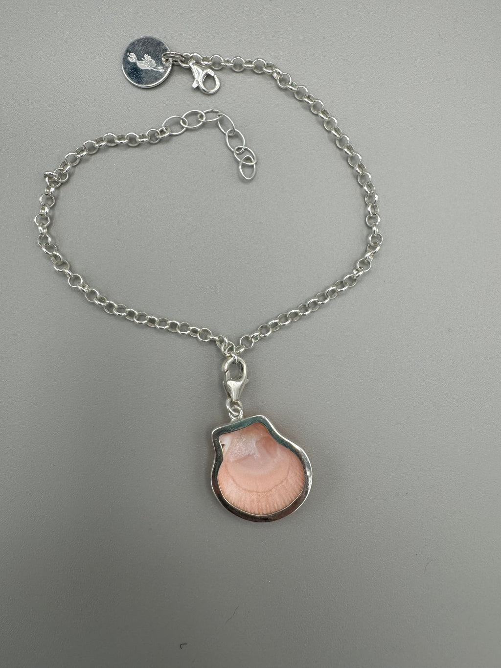 Sterling silver adjustable ankle bracelet featuring a pink scallop shell charm and swimming mermaid logo tag from southwest Florida.