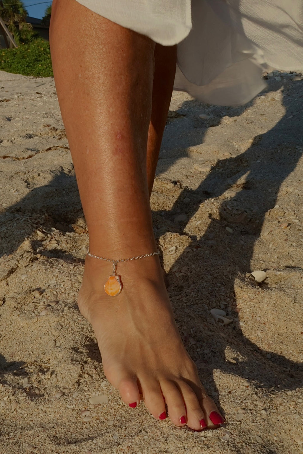 Sterling silver adjustable ankle bracelet featuring a pink scallop shell charm and swimming mermaid logo tag from southwest Florida.