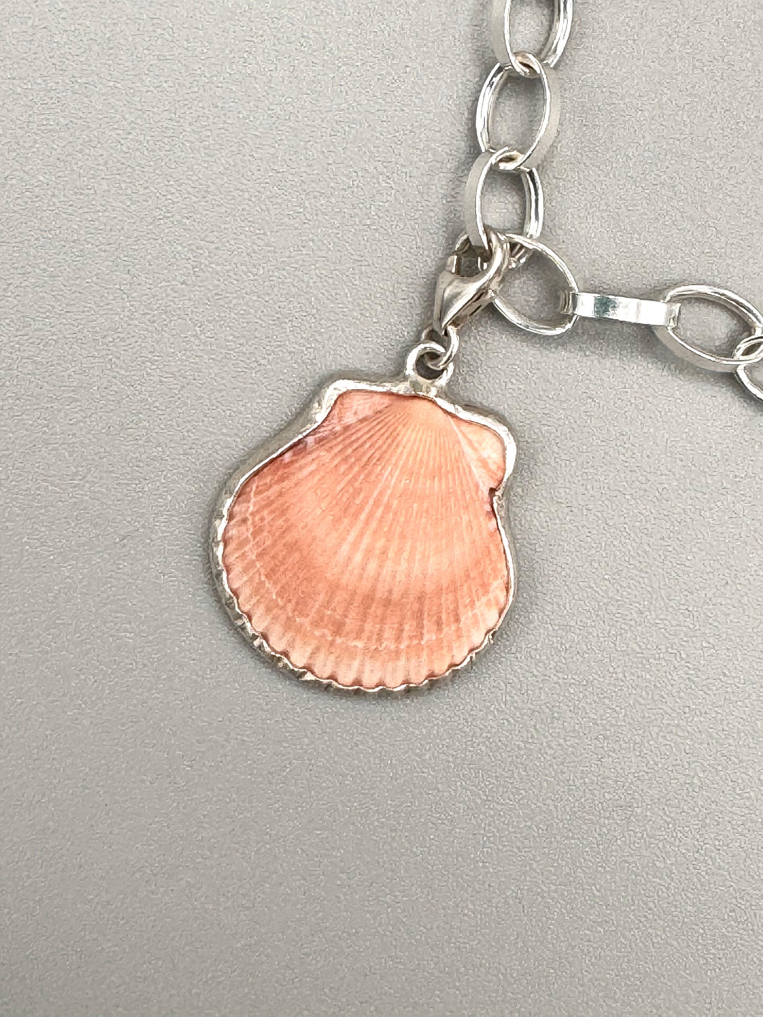 Sterling silver charm bracelet with pink scallop shell, fossilized shark tooth, and aquamarine sea glass from Japan — ocean-inspired handcrafted jewelry.