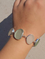Sterling silver bracelet featuring alternating pieces of white and sea foam Sicilian sea glass with adjustable clasp.