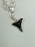 Sterling silver charm bracelet featuring seafoam green sea glass, fossilized shark tooth, and turkey wing shell.