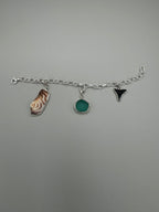Sterling silver charm bracelet featuring seafoam green sea glass, fossilized shark tooth, and turkey wing shell.