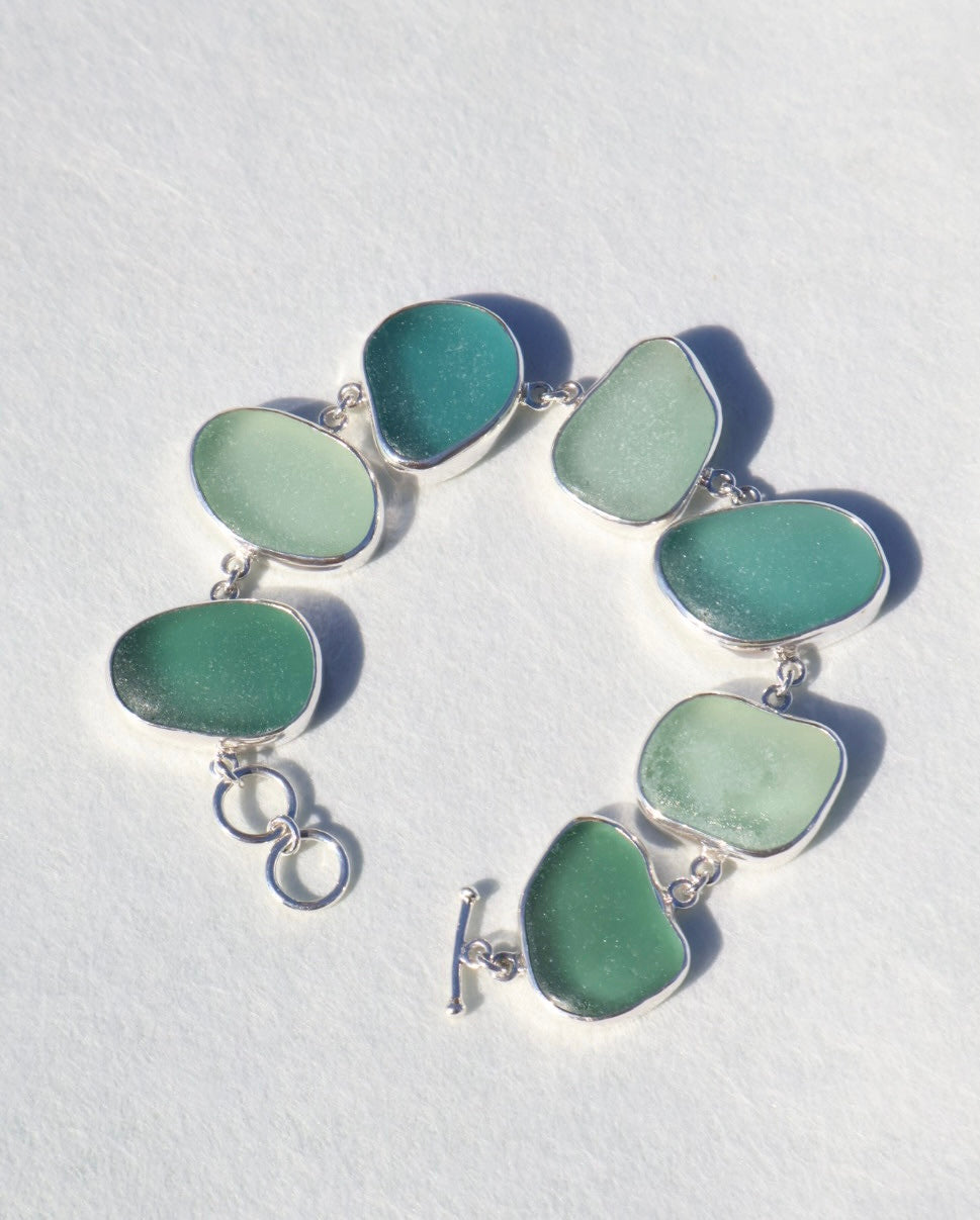 Sterling silver bracelet featuring alternating teal and sea foam Italian sea glass pieces with an adjustable clasp
