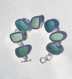 Sterling silver bracelet featuring alternating teal and sea foam Italian sea glass pieces with an adjustable clasp