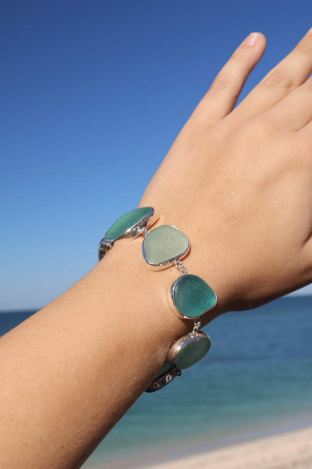 Sterling silver bracelet featuring alternating teal and sea foam Italian sea glass pieces with an adjustable clasp.